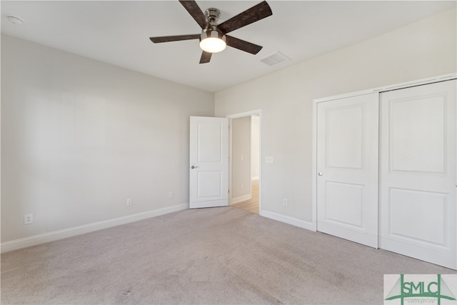 unfurnished bedroom featuring a closet, ceiling fan, and light colored carpet