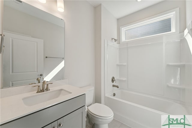 full bathroom with tile patterned floors, vanity, washtub / shower combination, and toilet