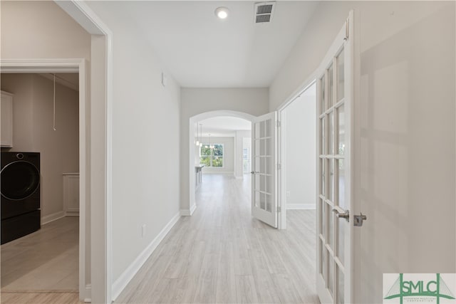 hall featuring french doors, washer / clothes dryer, and light hardwood / wood-style flooring