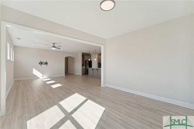 unfurnished living room featuring ceiling fan and light hardwood / wood-style flooring