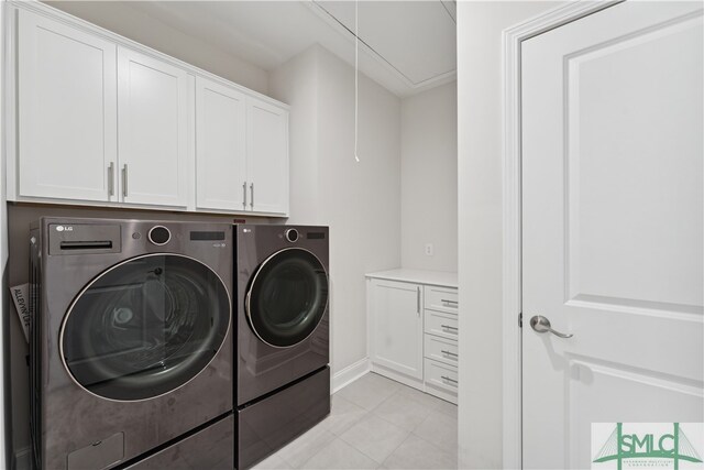 washroom featuring cabinets and washer and clothes dryer