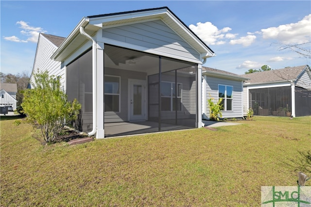 rear view of property with a sunroom and a lawn