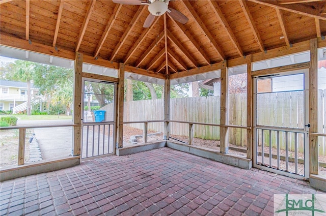 unfurnished sunroom with vaulted ceiling with beams, ceiling fan, and wooden ceiling