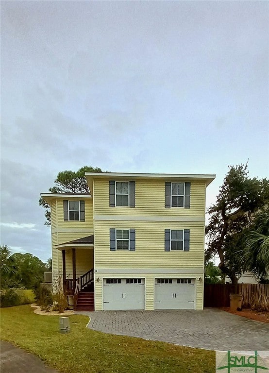 view of front facade featuring a porch, a front yard, and a garage