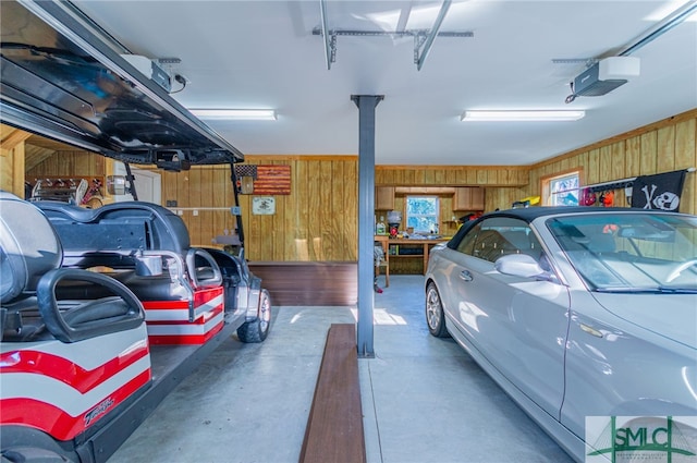 garage featuring a garage door opener and wooden walls