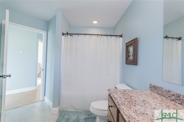 bathroom with tile patterned flooring, vanity, toilet, and walk in shower