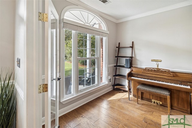 misc room with light hardwood / wood-style floors and ornamental molding