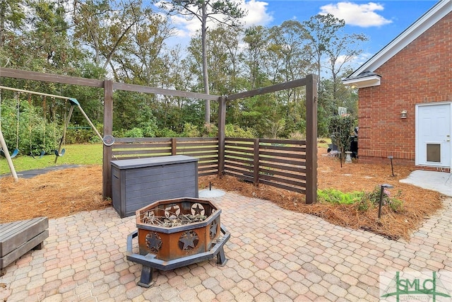 view of patio featuring a playground and an outdoor fire pit