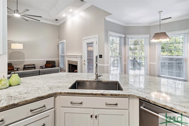 kitchen featuring plenty of natural light, white cabinets, hanging light fixtures, and sink