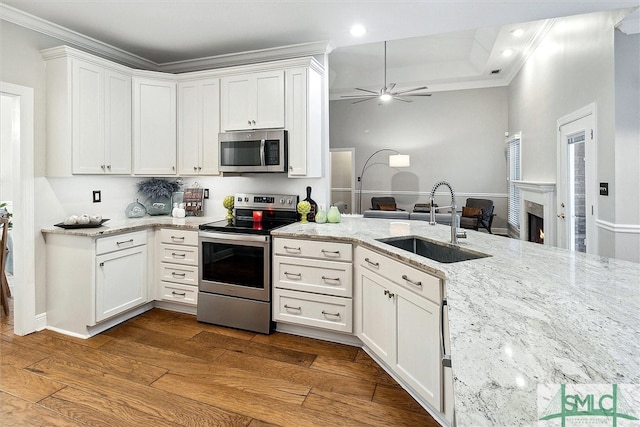 kitchen with hardwood / wood-style flooring, white cabinets, sink, and appliances with stainless steel finishes