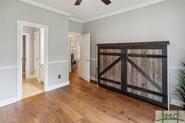 unfurnished bedroom with wood-type flooring, ensuite bathroom, ceiling fan, and ornamental molding