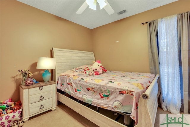 carpeted bedroom featuring a textured ceiling and ceiling fan