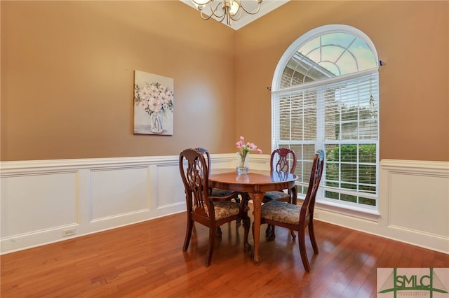 dining room with wood-type flooring and an inviting chandelier