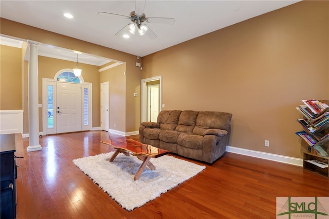 living room with hardwood / wood-style flooring, ceiling fan, crown molding, and decorative columns