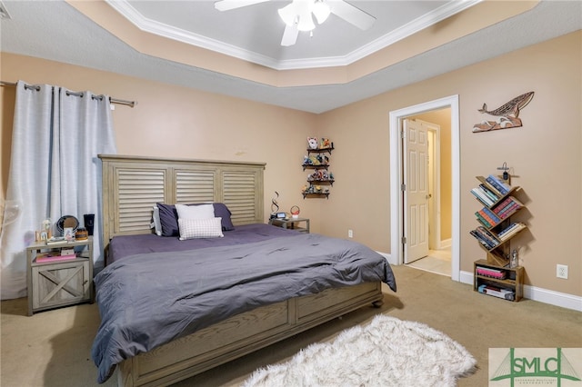 carpeted bedroom with ceiling fan, ornamental molding, and a tray ceiling