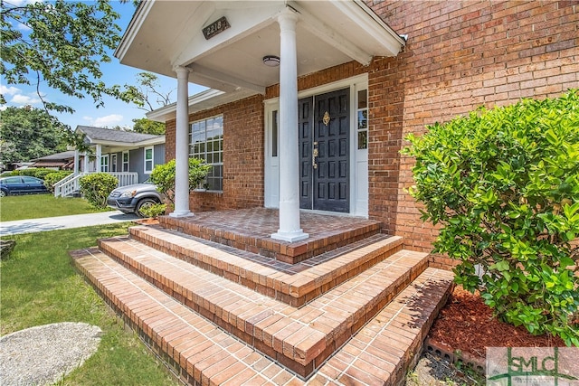 entrance to property with a yard and a porch