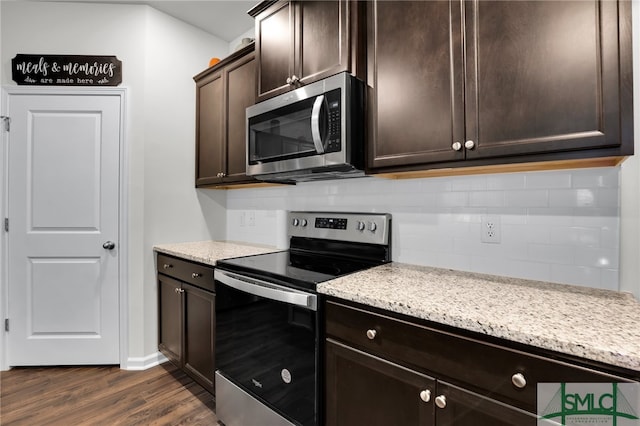 kitchen with dark brown cabinetry, light stone countertops, dark hardwood / wood-style floors, backsplash, and appliances with stainless steel finishes