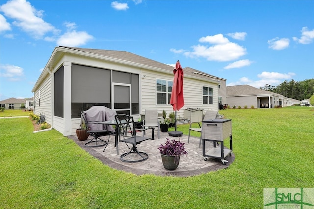 rear view of property featuring a patio, a lawn, and a sunroom