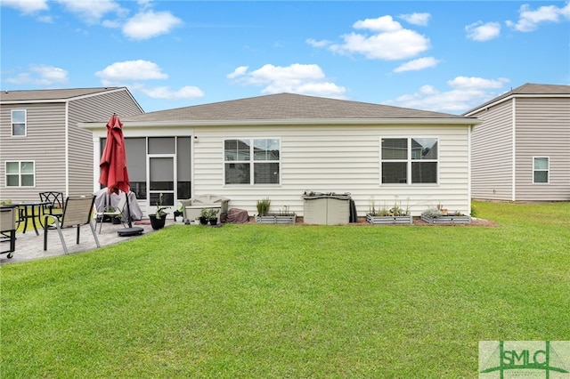 rear view of property featuring a yard and a patio area