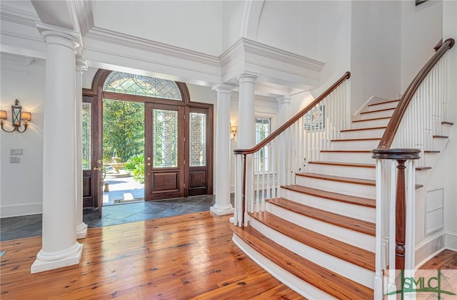 entryway with ornamental molding, a high ceiling, and hardwood / wood-style flooring