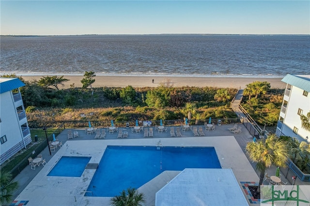 birds eye view of property with a water view and a beach view