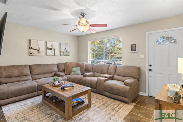 tiled living room featuring ceiling fan and a textured ceiling