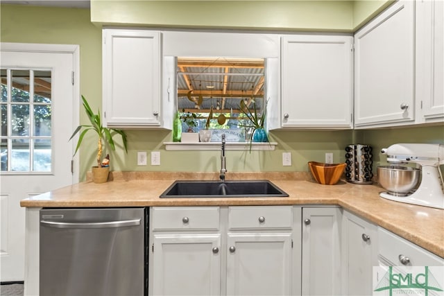 kitchen with stainless steel dishwasher, white cabinets, and sink