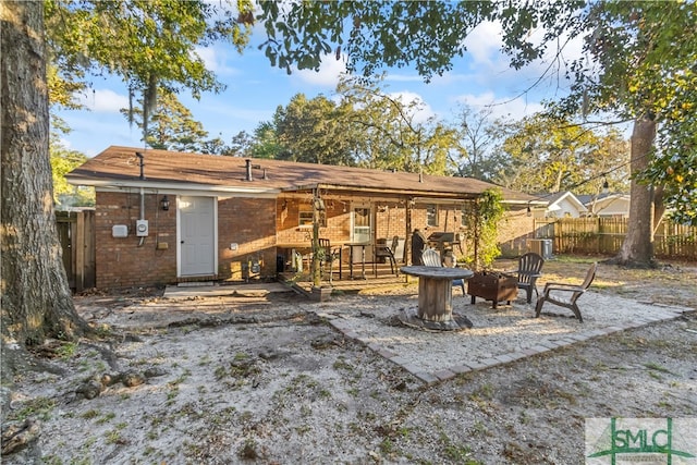 rear view of property featuring a fire pit