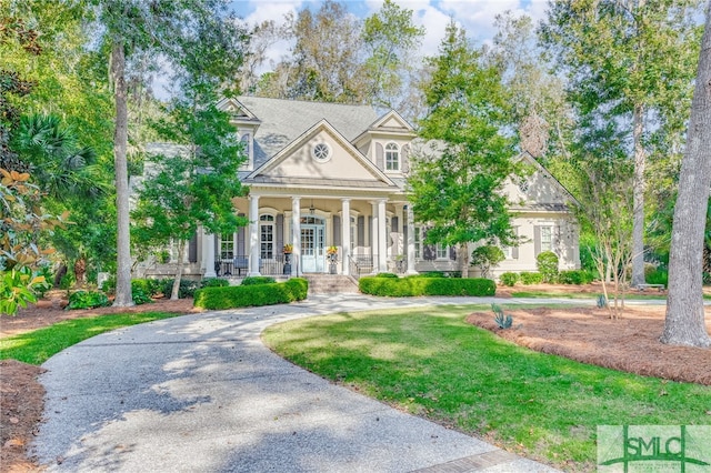 neoclassical / greek revival house featuring a porch and a front yard