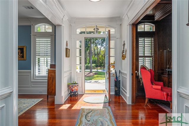 foyer entrance with dark hardwood / wood-style flooring and ornamental molding