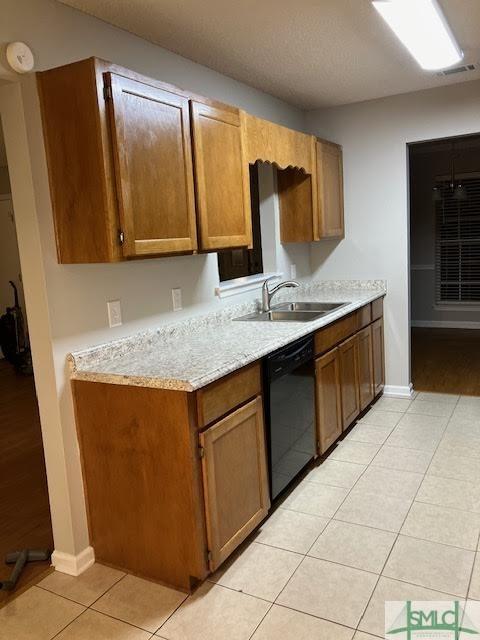 kitchen with black dishwasher, sink, and light tile patterned floors