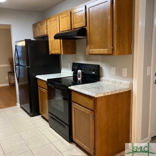 kitchen featuring light tile patterned floors and black appliances