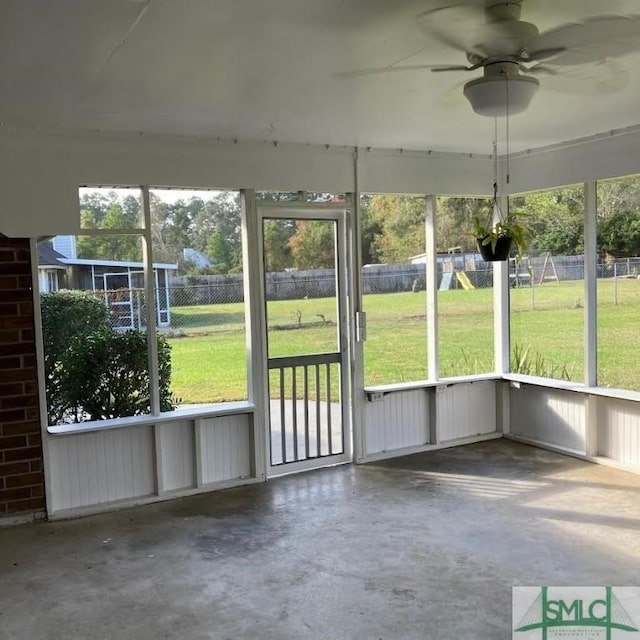 unfurnished sunroom featuring ceiling fan