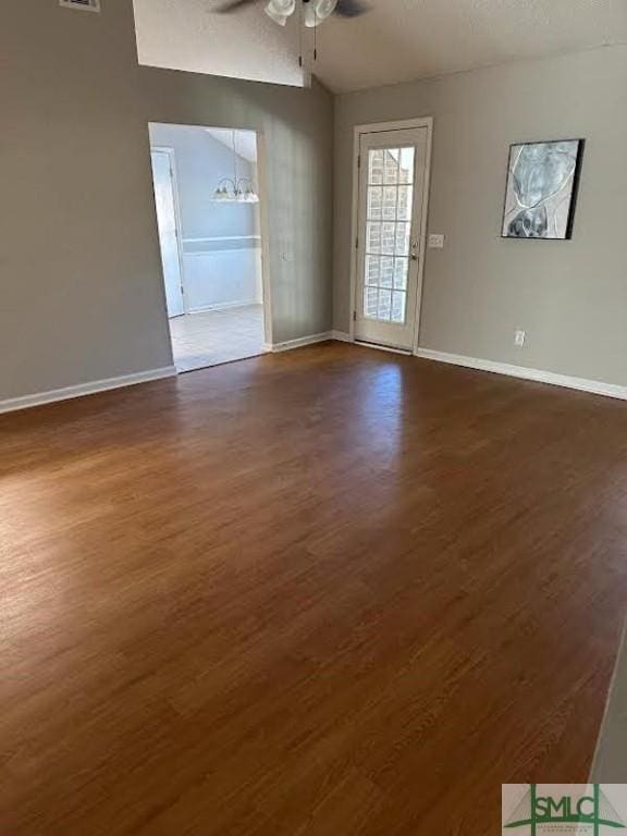 empty room with ceiling fan and dark hardwood / wood-style flooring