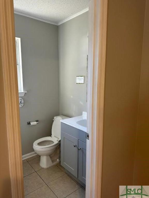 bathroom featuring vanity, tile patterned floors, a textured ceiling, and toilet