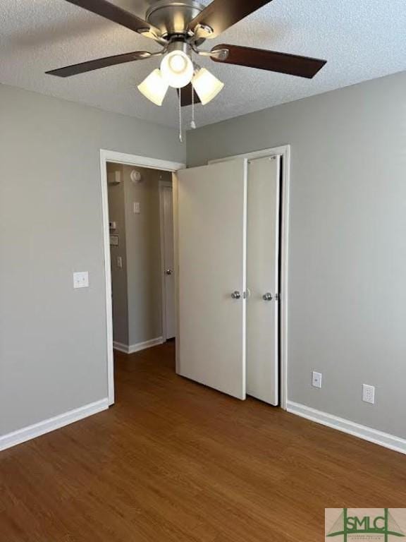 unfurnished bedroom with wood-type flooring, a textured ceiling, ceiling fan, and a closet