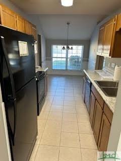 kitchen featuring light tile patterned floors, decorative light fixtures, and black appliances