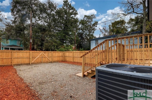 view of yard with central air condition unit and a wooden deck