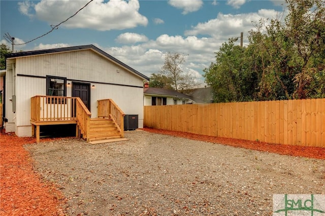 rear view of property featuring cooling unit and a deck