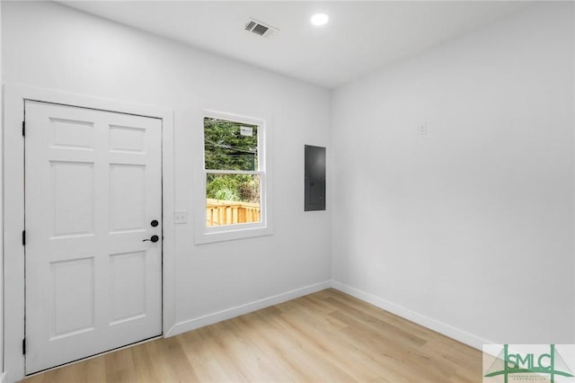 foyer entrance featuring electric panel and light hardwood / wood-style floors