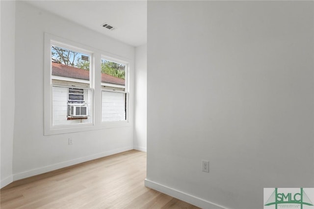 empty room with light hardwood / wood-style floors and cooling unit