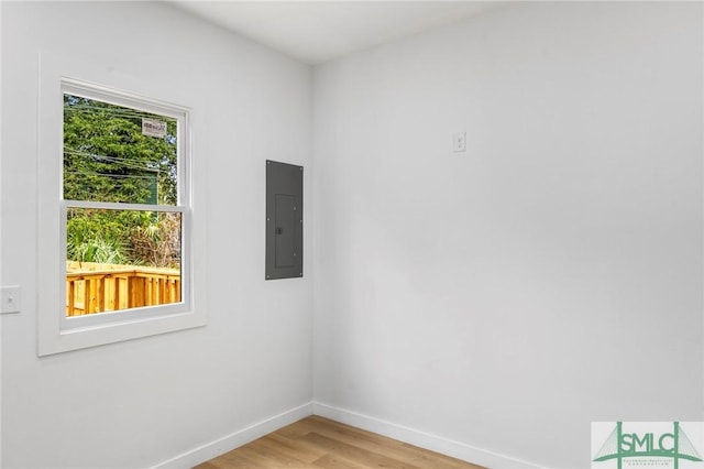 unfurnished room featuring electric panel and light hardwood / wood-style floors