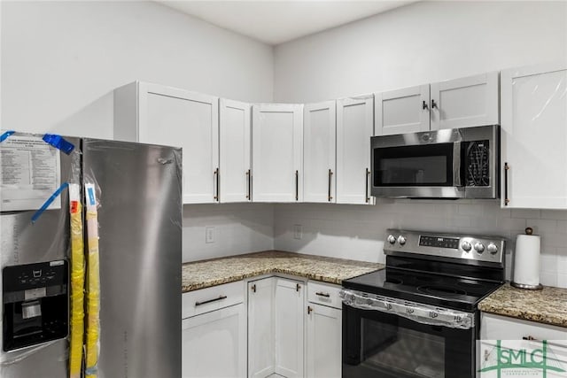 kitchen with backsplash, white cabinetry, light stone counters, and appliances with stainless steel finishes