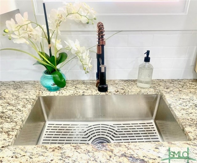 details featuring light stone countertops and sink