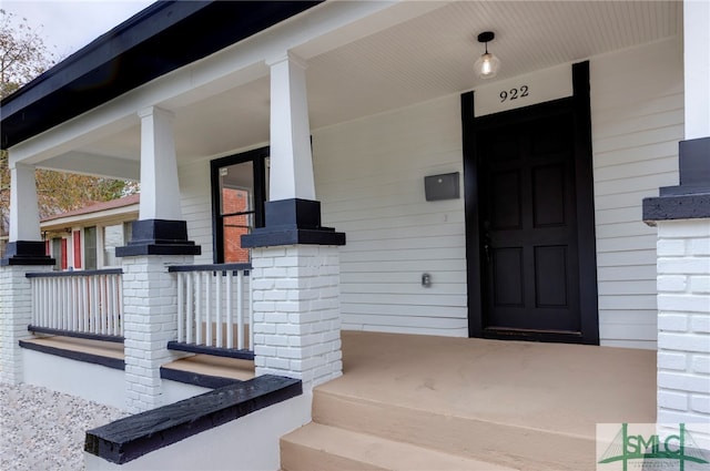 view of exterior entry with a porch