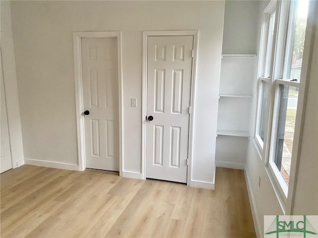 unfurnished bedroom with multiple closets and light hardwood / wood-style flooring