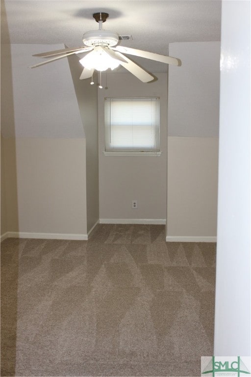 carpeted spare room featuring ceiling fan and lofted ceiling