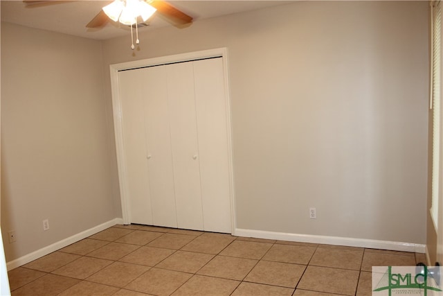 unfurnished bedroom featuring light tile patterned floors, a closet, and ceiling fan