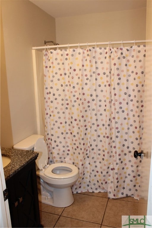 bathroom featuring toilet, vanity, and tile patterned floors