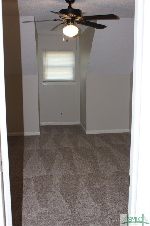 empty room featuring ceiling fan, carpet, and a textured ceiling